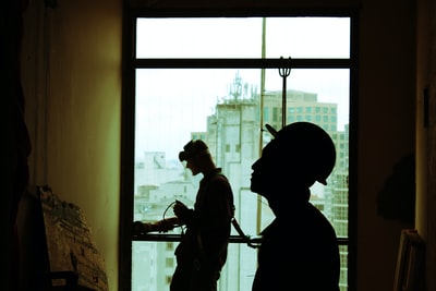 两个戴着安全帽的男人站在透明的玻璃窗旁
